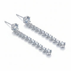 Silver drop earrings with prong-set round moissanite stones on slender stems
