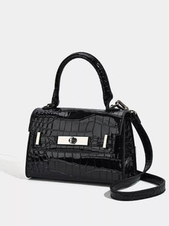 Black croc-embossed top-handle handbag, side view with shoulder strap