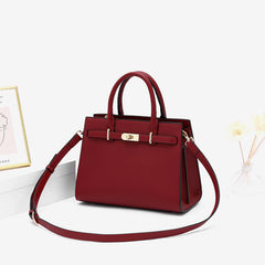 Burgundy leather handbag with detachable shoulder strap draped across body
