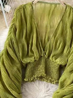 Green blouse close-up: ruched smocked bodice and gathered long sleeves
