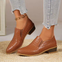 Point-toe block heel loafers in tan/brown with textured finish and gold chain ankle detail.