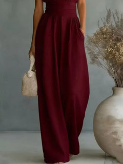 Burgundy wide-leg jumpsuit with V-neck, smocked bodice, and flowing skirt