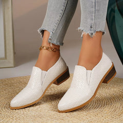 Point-toe block heel loafers in white with textured finish and gold chain ankle detail.