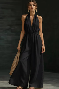 Black halter-neck wide-leg jumpsuit with deep V neckline and flowing wide legs