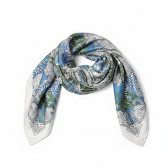 Blue silk scarf with white and green leaf and paisley motifs, loosely draped