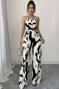 Sleeveless wide-leg jumpsuit with abstract black-and-white print, halter neck, open wide legs