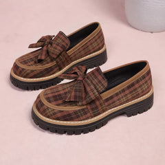 Pair of plaid chunky loafers with front bows, tan plaid uppers and rugged sole