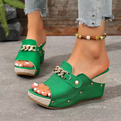 Green open-toe wedge sandals with chain buckle strap and round metal studs.