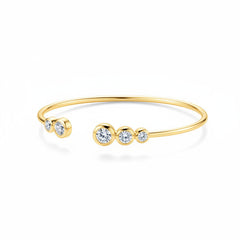 Gold-tone bracelet with small end stone and three-stone centerpiece on open cuff