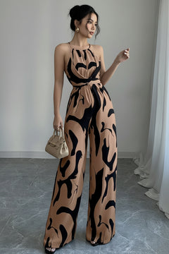 Sleeveless wide-leg jumpsuit with abstract tan-and-black print and tied waist, side view