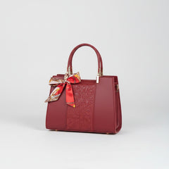 Red embossed leather top-handle handbag with bow scarf and structured sides