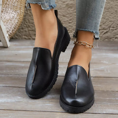 Black round-toe loafers with block heel, V-cut vamp, and ridged sole edge