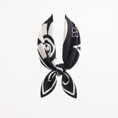 Square flower silk scarf knotted in black and white with flower and swirl motifs